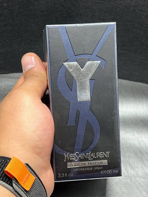 a person holding a box of y for a perfume