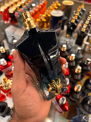 a hand holding a black bottle of perfume