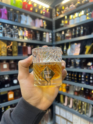 a person holding up a glass of alcohol in a store