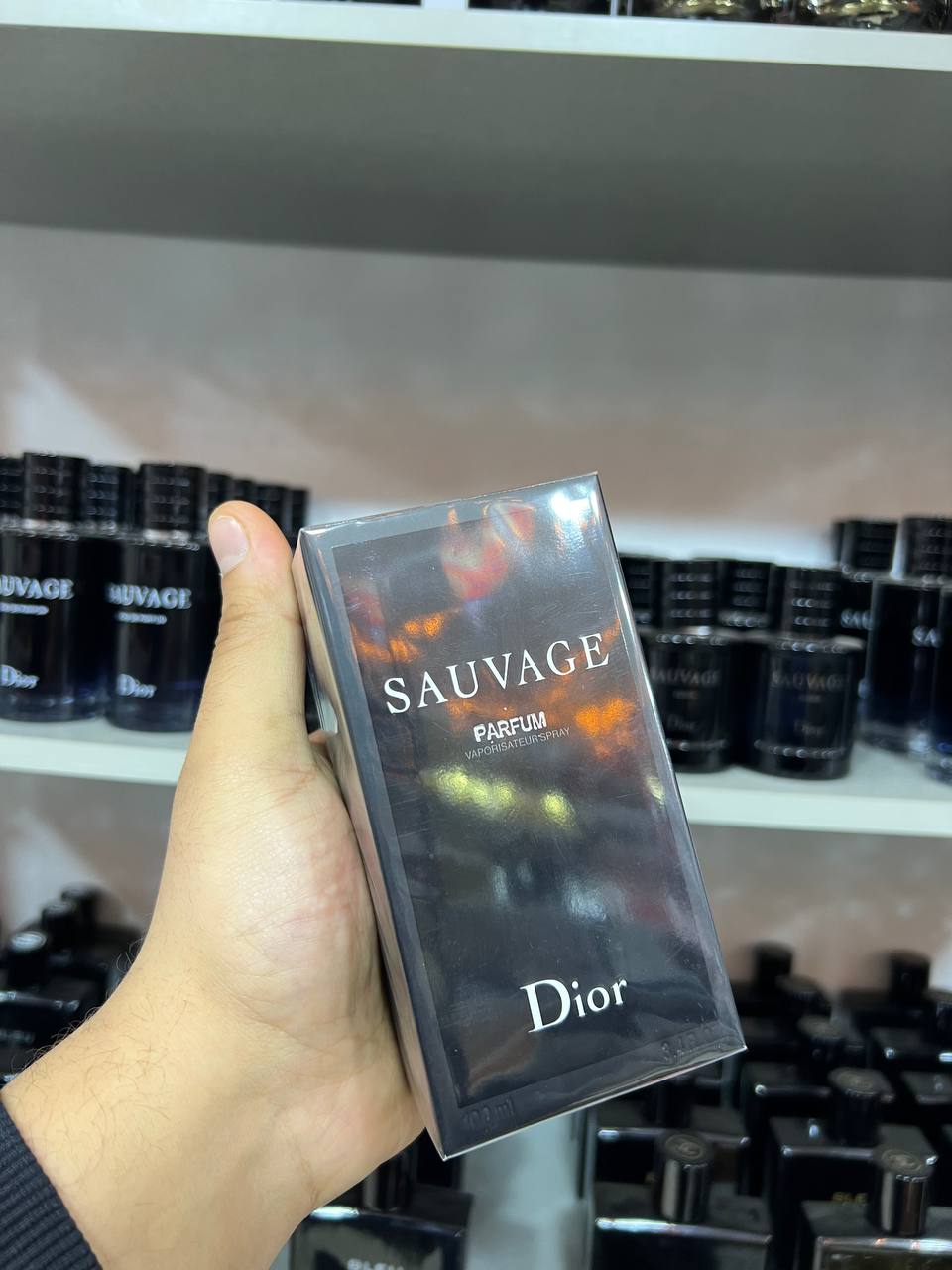a hand holding a box of soap in a store