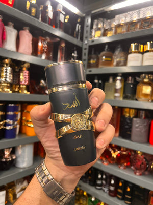 a person holding a black and gold flask in a store