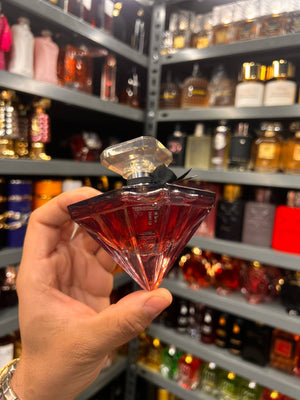 a person holding a small glass in front of a shelf of liquor bottles