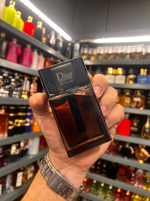 a person holding a bottle of perfume in a store