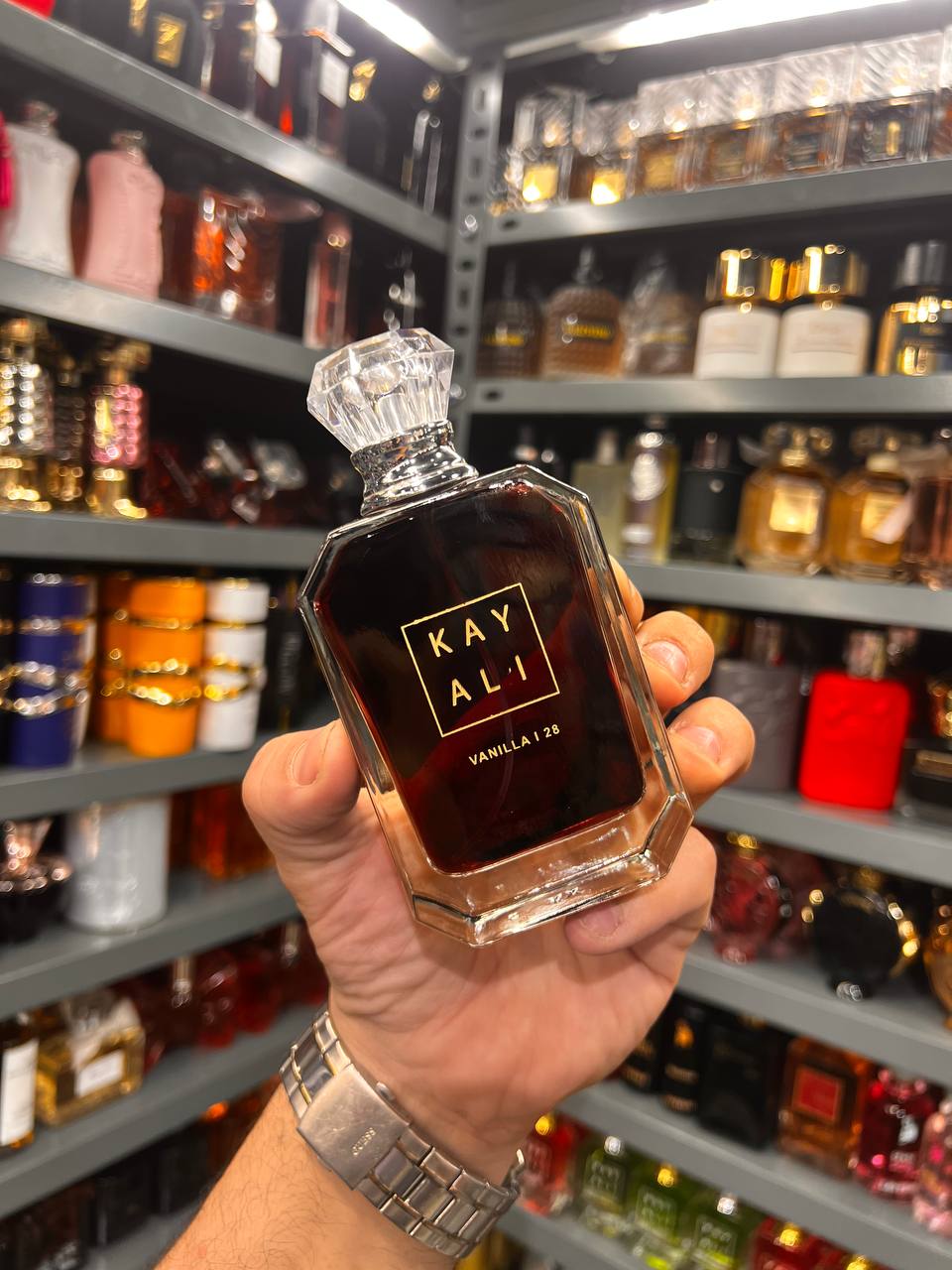 a person holding a bottle of perfume in a store