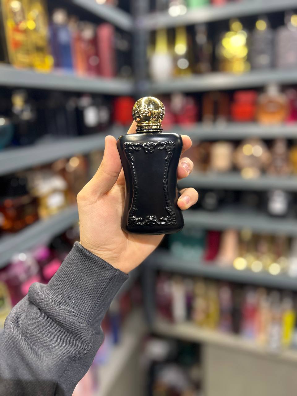 a person holding a black bottle in a store