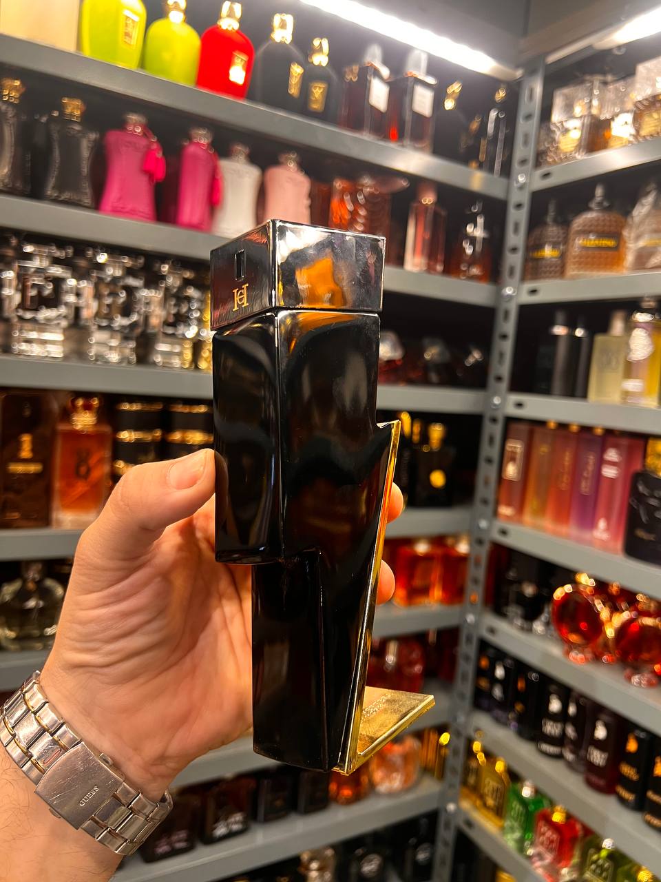 a person holding a bottle of perfume in a store