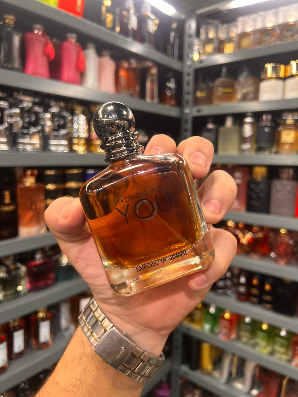 a person holding a bottle of perfume in a store