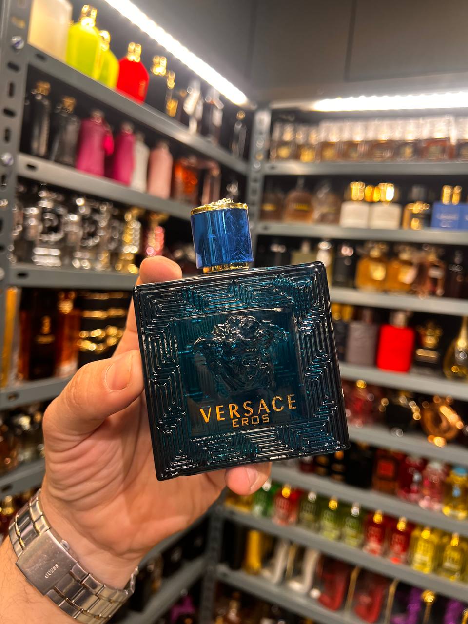a person holding a bottle of perfume in a store