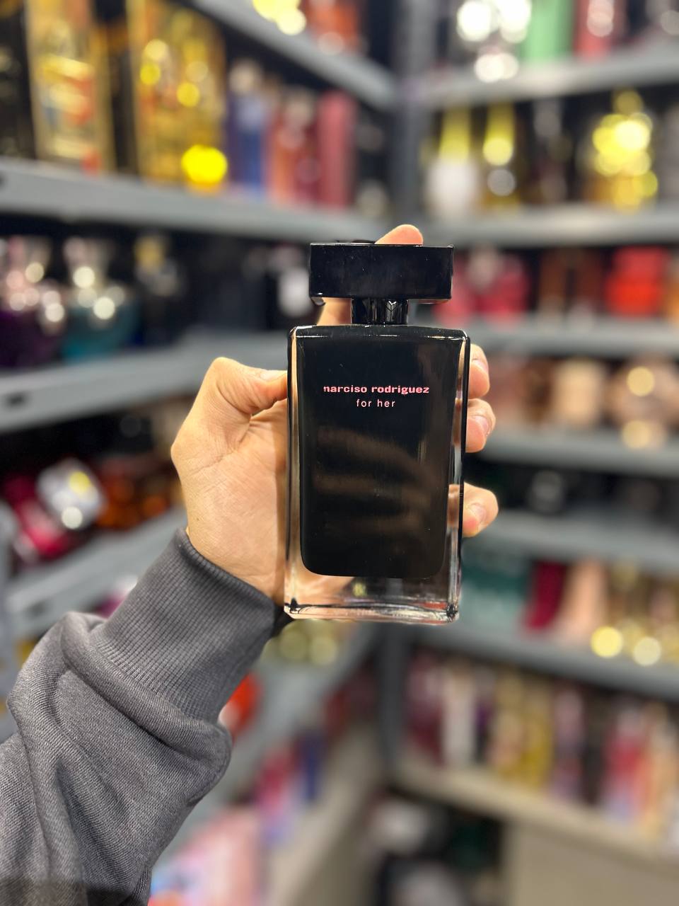 a person holding a bottle of perfume in a store