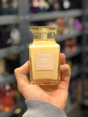 a person holding a bottle of perfume in their hand