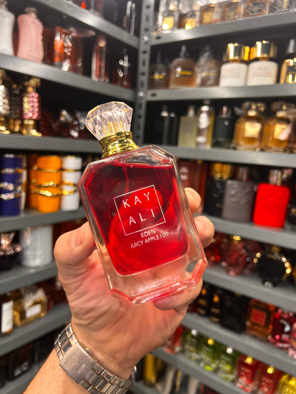 a person holding a bottle of red liquid in a store