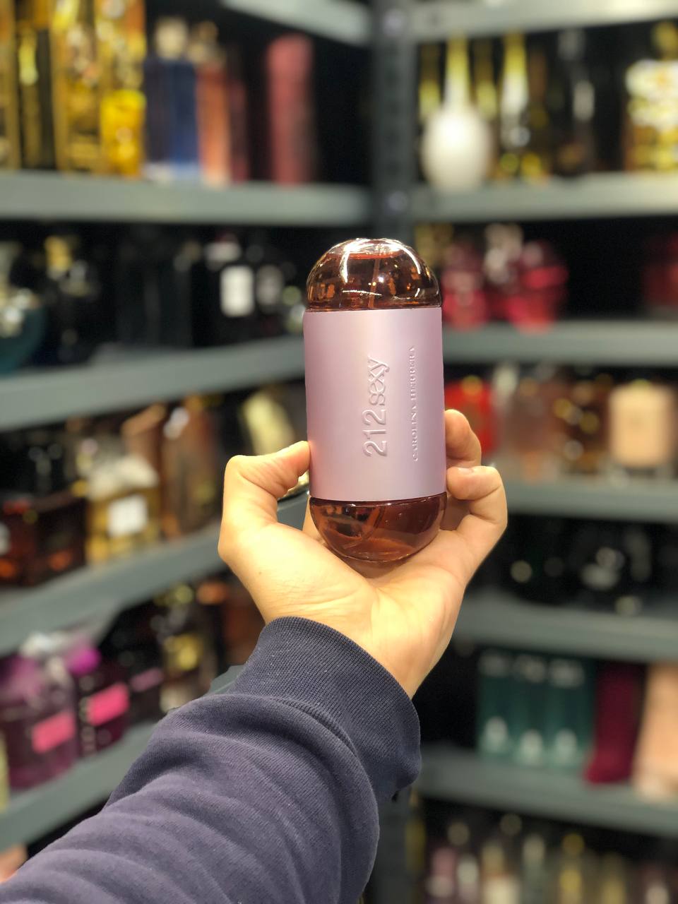 a person holding a bottle of wine in a store