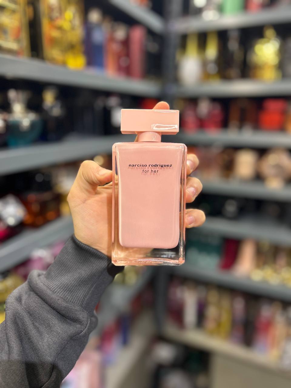 a person holding a bottle of perfume in a store