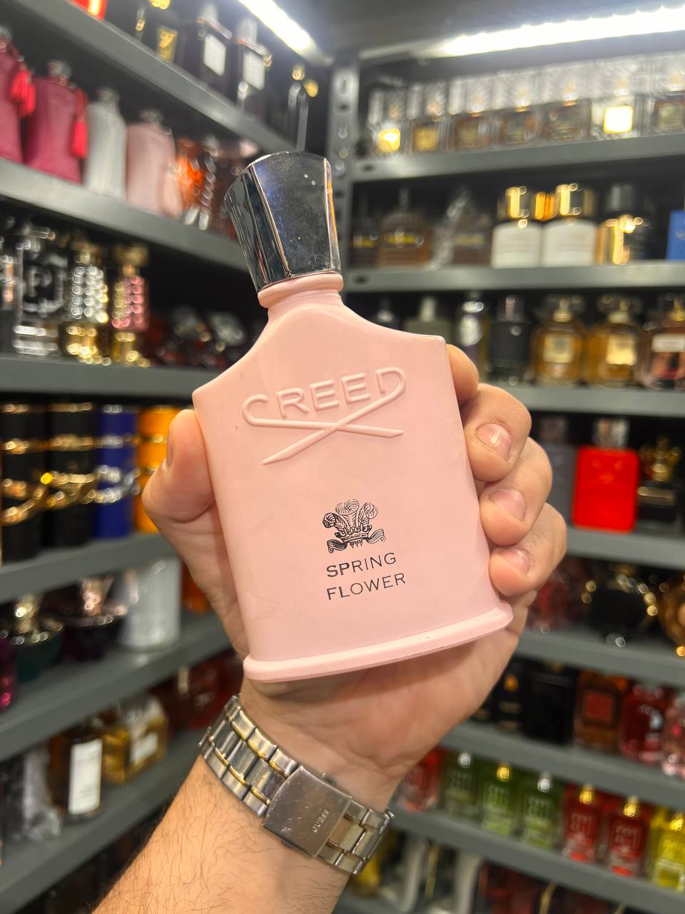 a person holding a pink spray bottle in a store