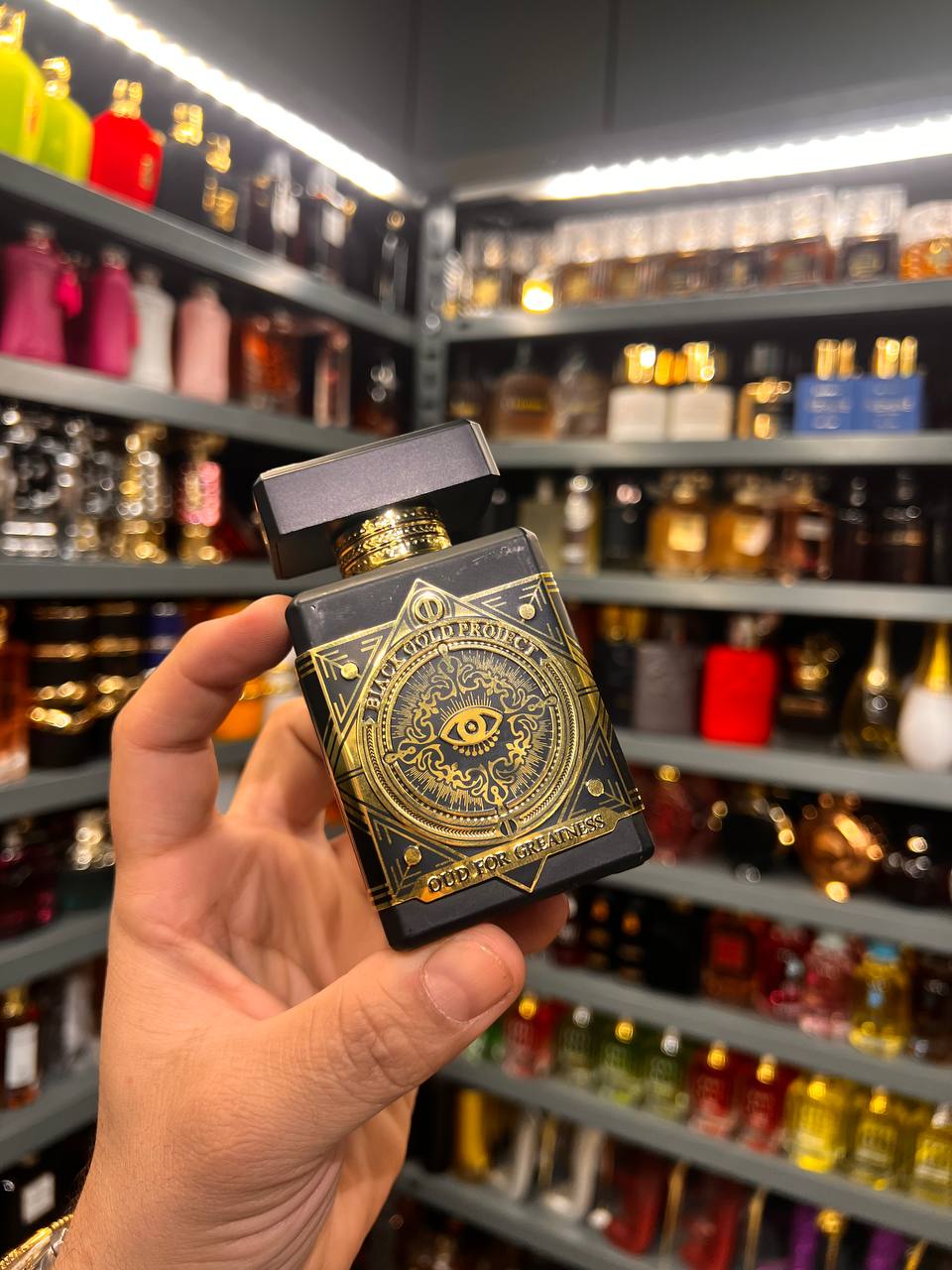 a person holding a box of perfume in a store