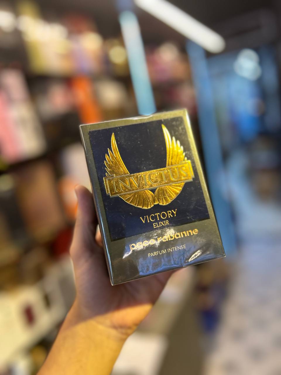 a person holding up a box of victory cigarettes
