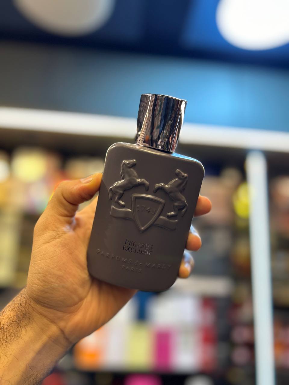 a hand holding a flask shaped like a flask