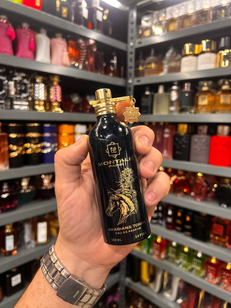a person holding a black bottle in a store