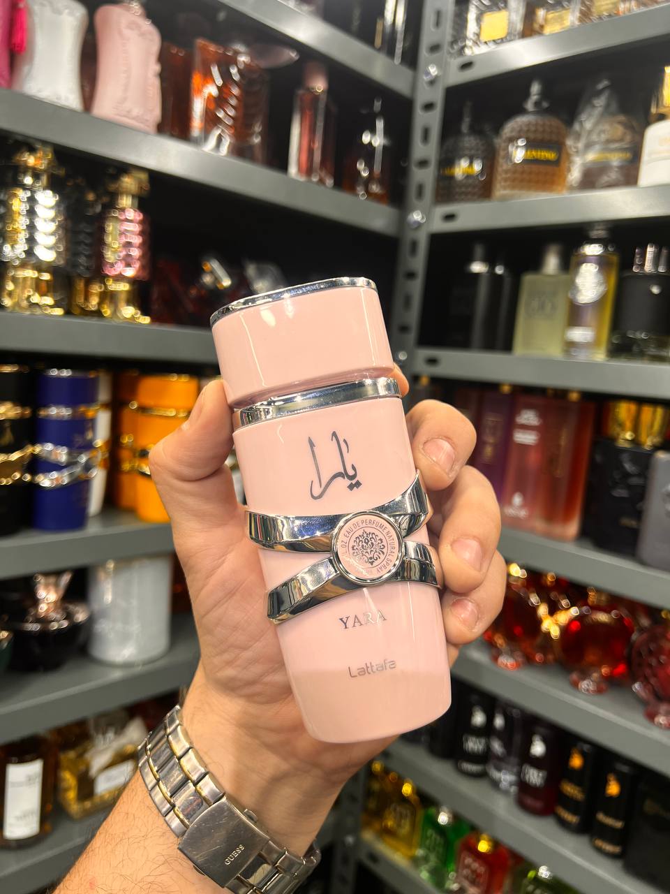 a person holding a pink bottle in a store