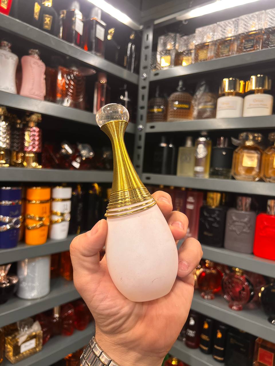 a person holding a bottle of perfume in a store