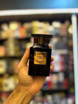 a hand holding a bottle of perfume in a store