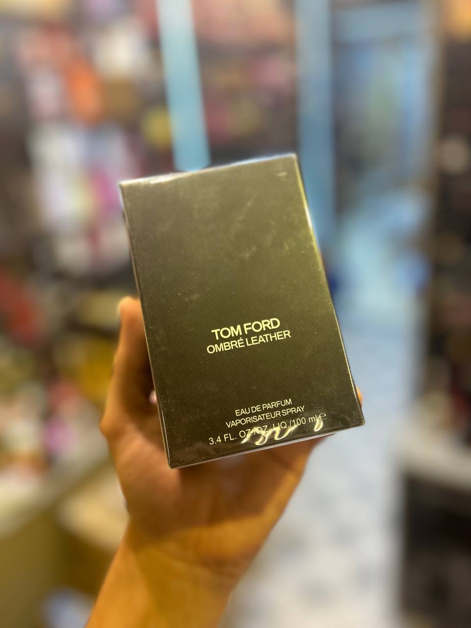a person holding up a box of tom ford