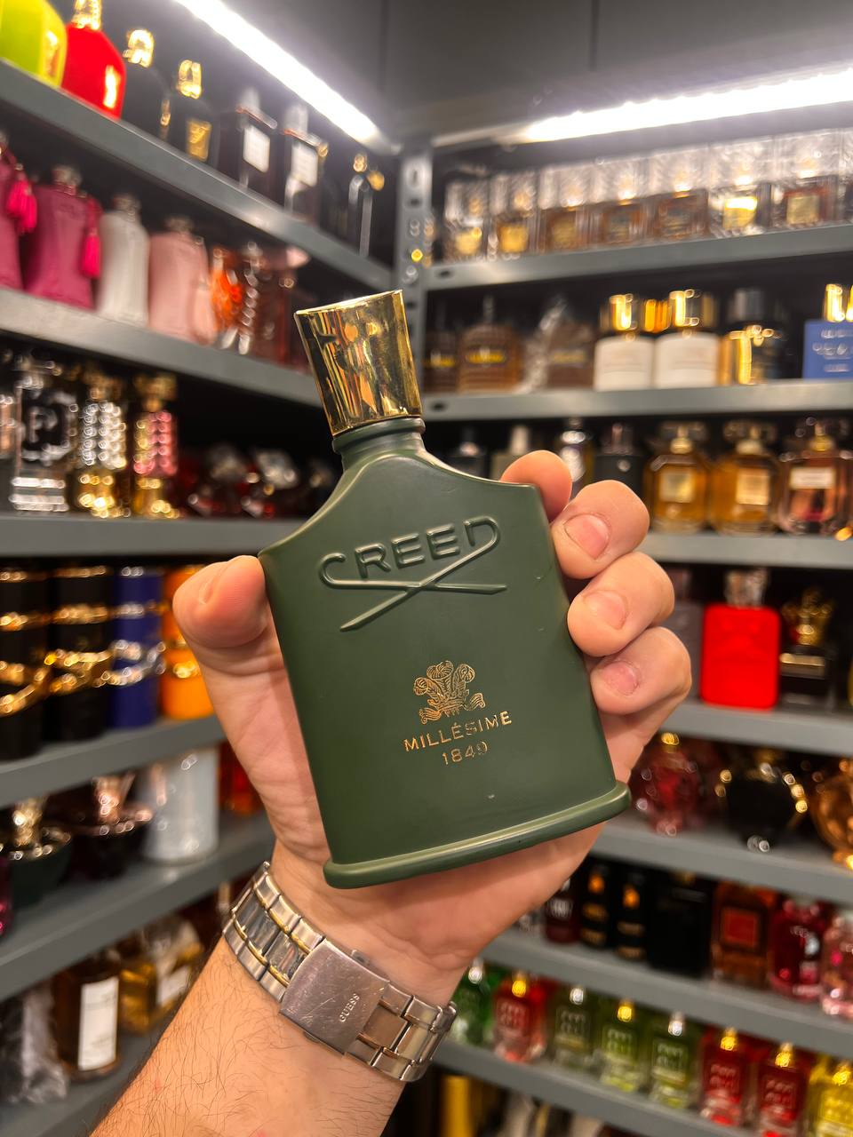 a person holding a green bottle in a store