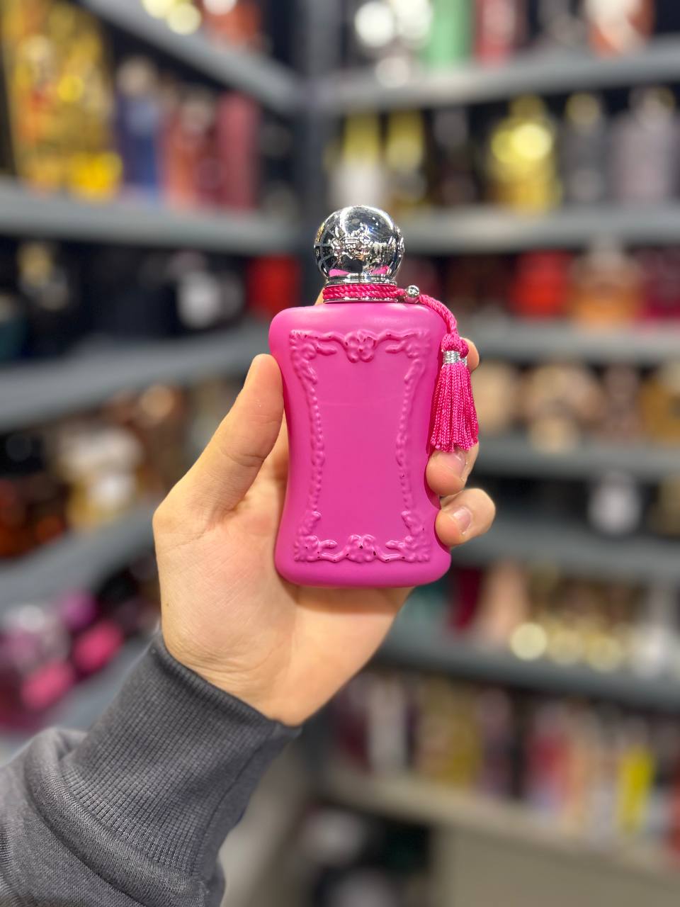 a person holding a pink flask in a store