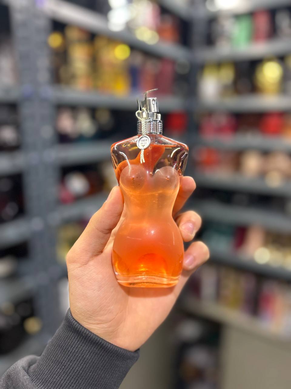 a person holding a bottle of perfume in a store