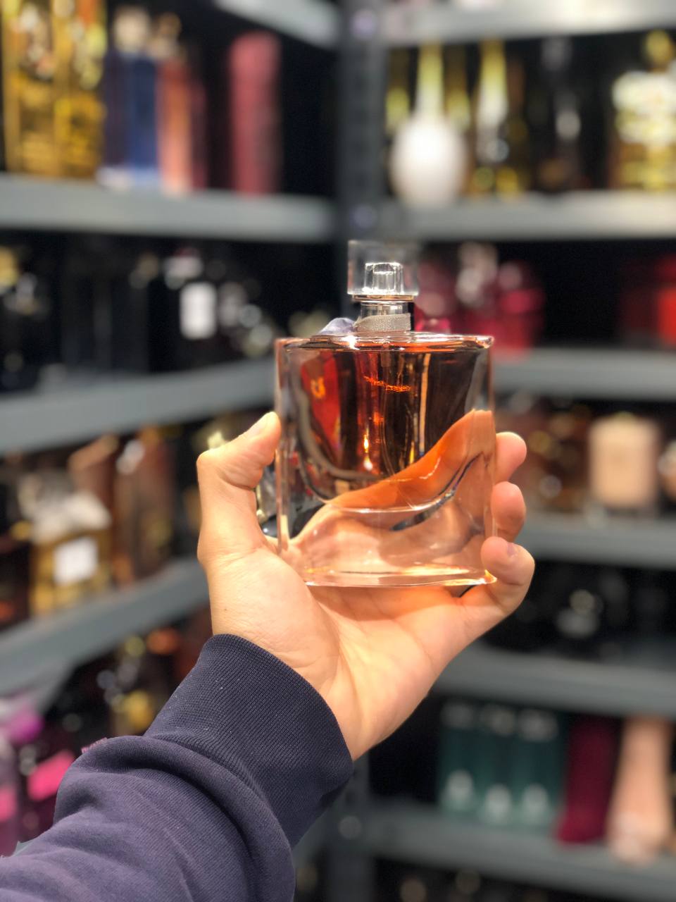 a person holding a bottle of perfume in a store