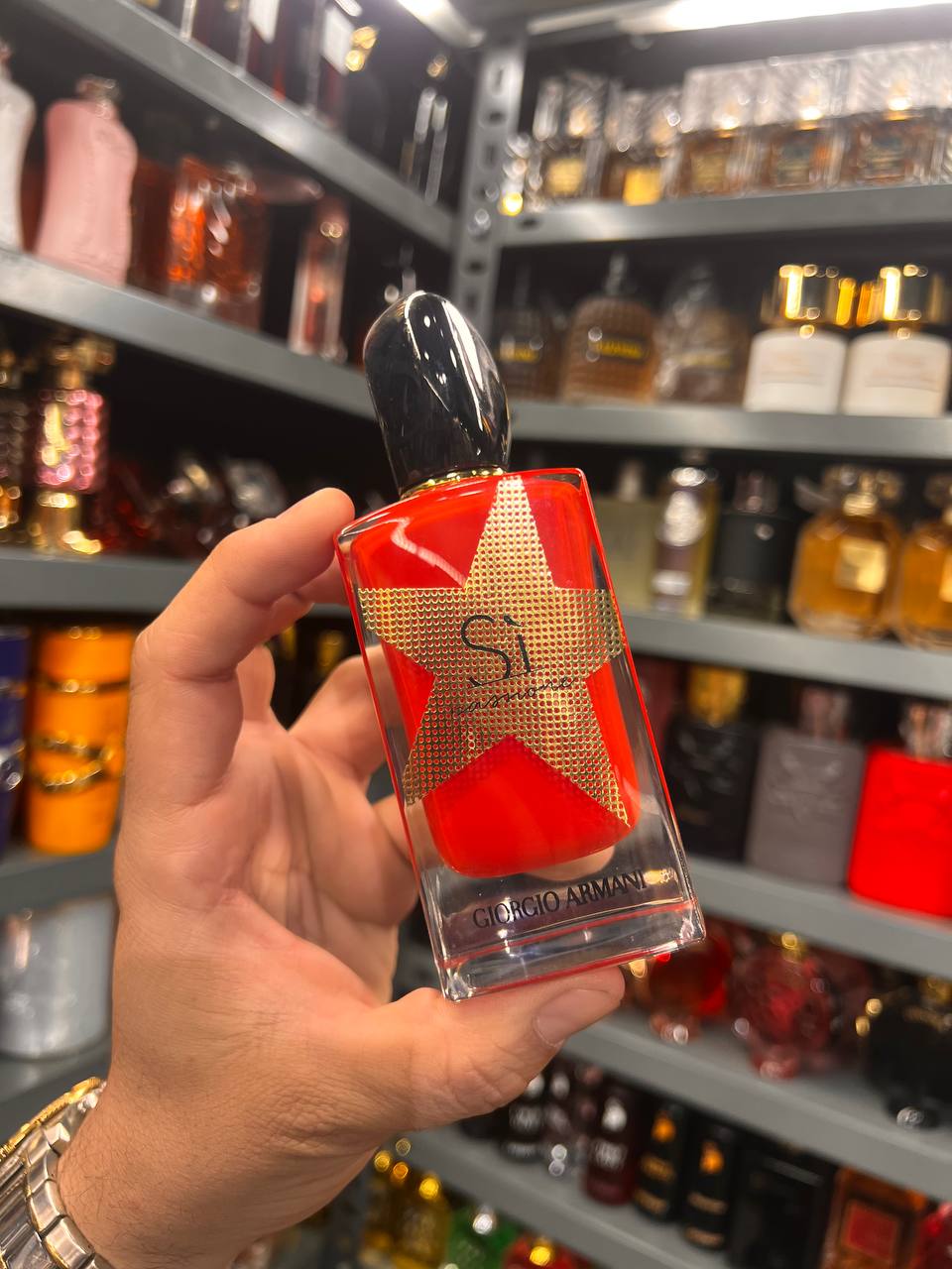 a person holding a bottle of perfume in a store